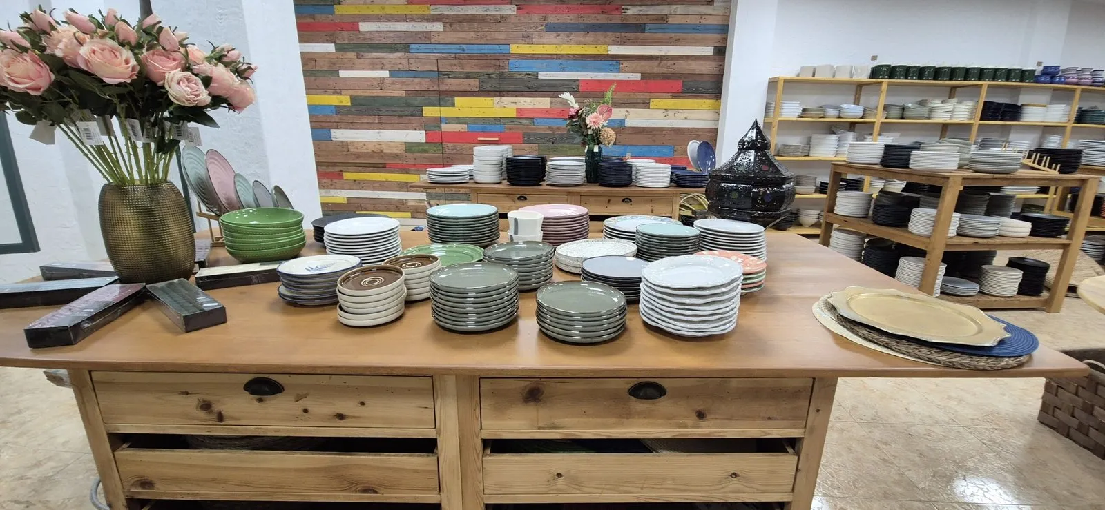 Pilas de platos de colores sobre una mesa de madera en la tienda